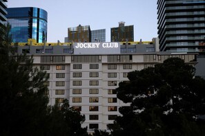 A hotel named Jockey Club with a modern facade, multiple windows, and a prominent sign.