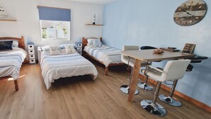 Une chambre confortable avec deux lits simples, une petite table et une chaise.