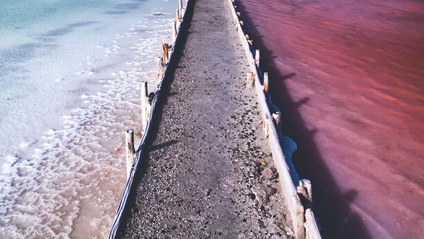 A pier extending into a body of water with a clear sky above.