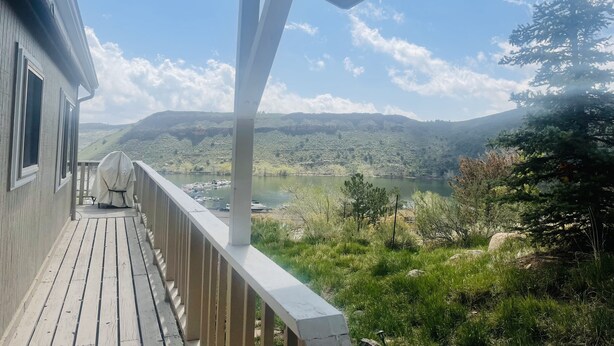 A wooden deck with a view of a lake and mountains. - Lake View Casa (Fort Collins)
