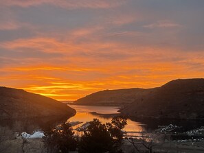A sunset view over a valley with a river, surrounded by hills. - Lake View Casa (Fort Collins)