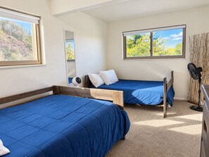 A room with two single beds, a mirror, and a window with a view of trees. - Lake View Casa (Fort Collins)