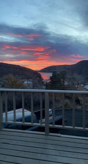 A deck with a view of a sunset over a valley and a body of water. - Lake View Casa (Fort Collins)
