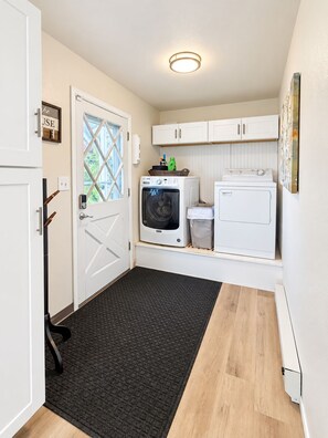 A laundry room with a washing machine, dryer, and a small cabinet. - Lake View Casa (Fort Collins)