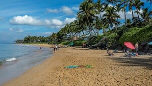 A beach with palm trees, a sandy shore, and umbrellas. - Wailea Ekahi 10C - Just steps away from Main Pool & Beach!  - Family Managed (Kihei)