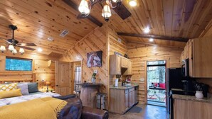 Un interior de cabaña acogedor con detalles de madera, un comedor y una cocina.