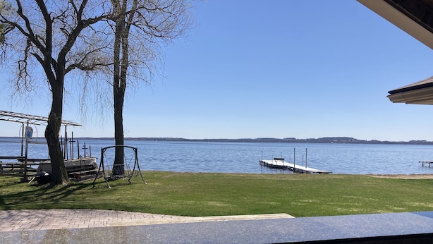 A view of a lake with a dock and a swing set.