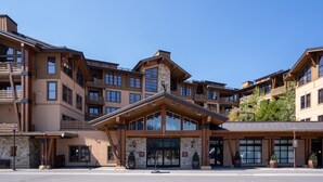 A multi-story hotel with a stone facade, large windows, and balconies. - Village at Palisades Tahoe Condo #6, in Building 5, Ski In/Out, with Mountain View!! (Olympic Valley)