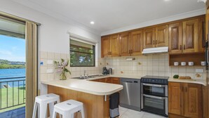 Una cocina moderna con armarios de madera, una isla grande, lavavajillas y horno.