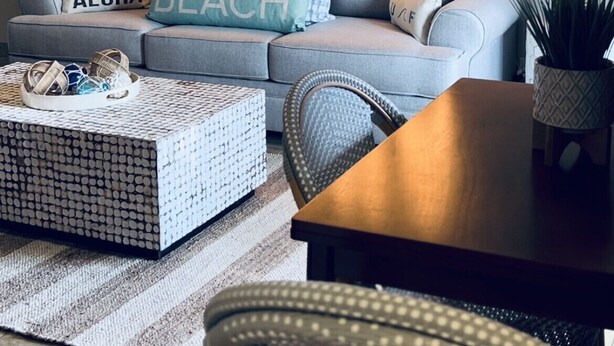 A modern living room with a grey sofa, a coffee table, and a wall-mounted light sign that reads "ALOHA". - Surf Cove - Ocean - Jeep  (Kihei)