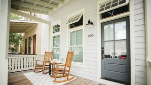 A porch with wooden rocking chairs, a white railing, and a door marked with the number 906. - South Main Chalet- Luxury living in BV- STR-120 (Buena Vista)
