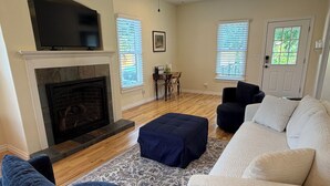 A living room with a fireplace, a television, a sofa, and a coffee table. - Charming Dover Home, with Large Fenced Yard and Garden View (Dover)