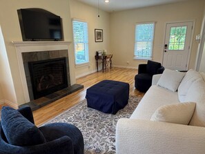 A living room with a fireplace, a television, a sofa, and a coffee table. - Charming Dover Home, with Large Fenced Yard and Garden View (Dover)