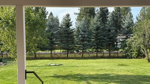 A well-maintained lawn with a stone patio and a wooden fence in the background. - Charming Dover Home, with Large Fenced Yard and Garden View (Dover)