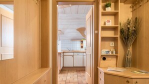 Un interior de madera con una zona de cocina, que incluye armarios y una encimera.