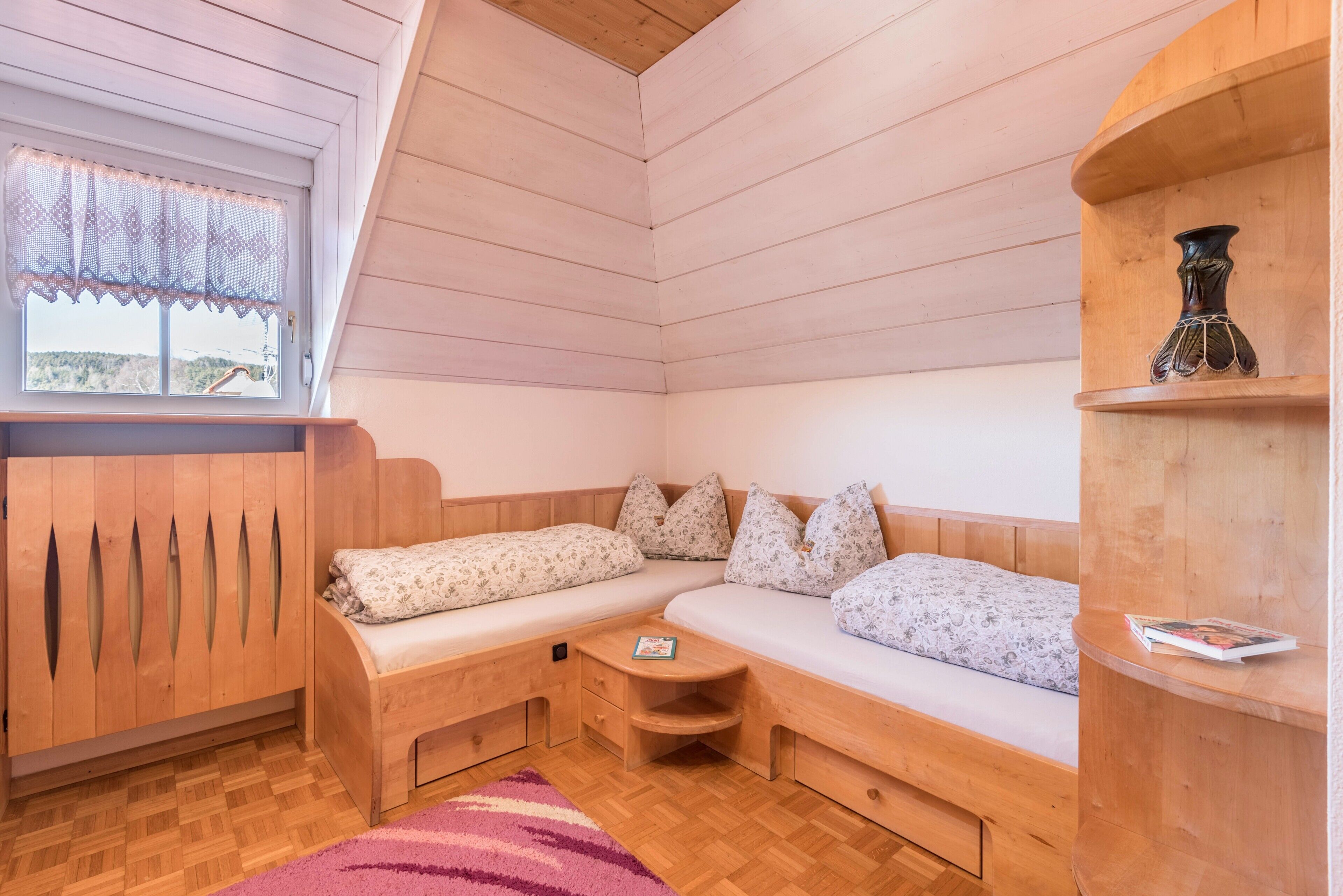 Una habitación acogedora con un banco de madera, una mesita y una estantería.