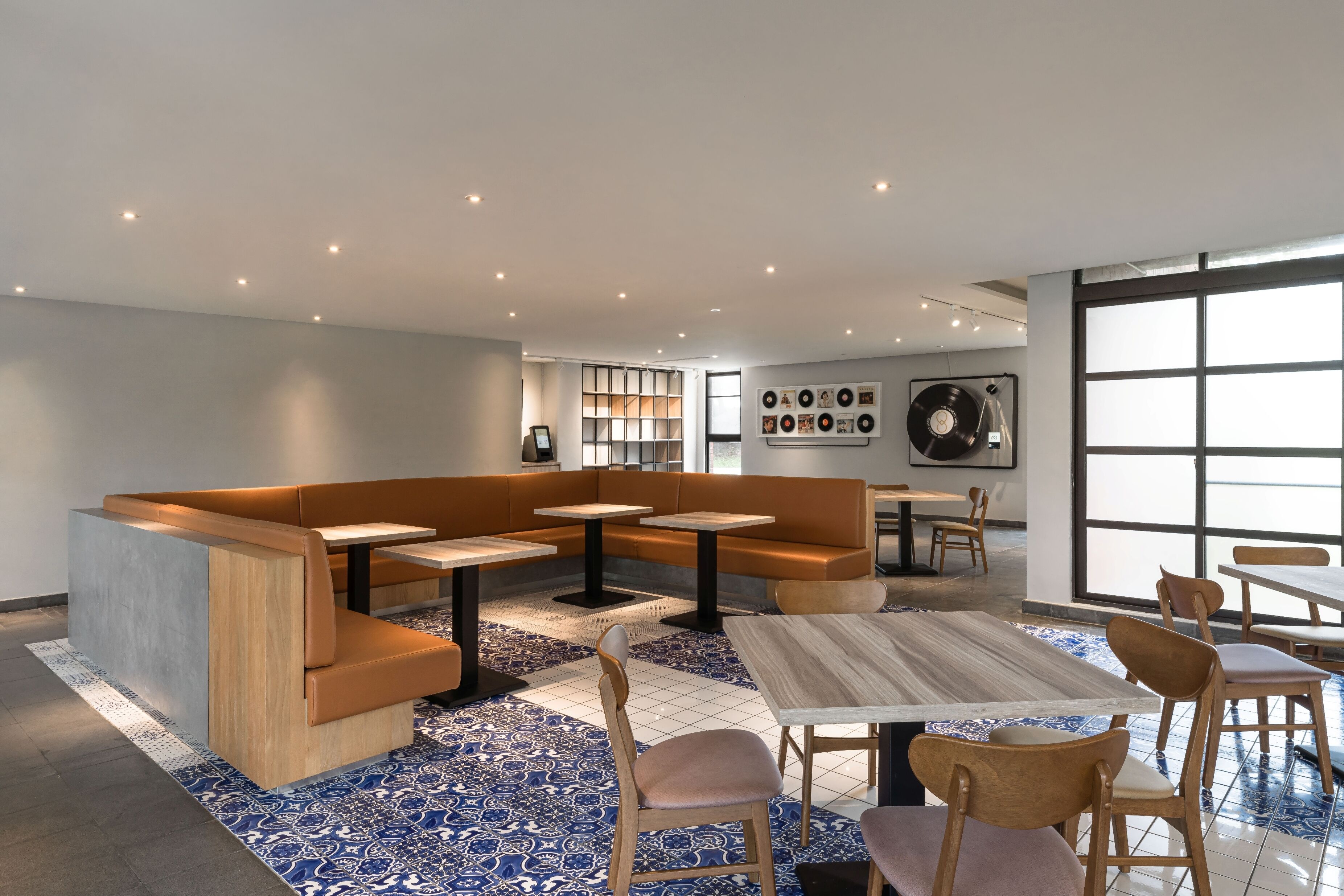 A modern lounge area with seating, tables, and a large window.