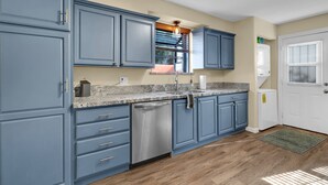 A kitchen with blue cabinets, a stainless steel dishwasher, and a granite countertop. - Midtown Territorial Home Beautifully Updated + Convenient  2 miles U of A (Tucson)