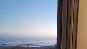 Una ventana con vista a la playa y al océano.