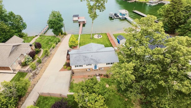 A residential area with a house, a dock, and a lake. - Lake Escape - Beautiful Lake Views! - Hot Tub - Game Room - Kayaks - Dock - Firepit - Pet Friendly (Sherrills Ford)