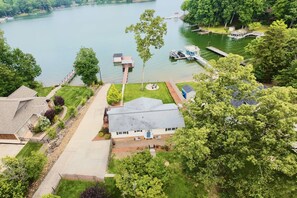 A residential area with a house, a dock, and a lake. - Lake Escape - Beautiful Lake Views! - Hot Tub - Game Room - Kayaks - Dock - Firepit - Pet Friendly (Sherrills Ford)