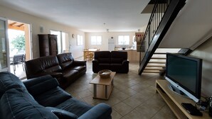 A spacious living room with a large TV, leather sofas, and a dining area. - House / Villa - St genest de beauzon (Saint Genest de Beauzon)