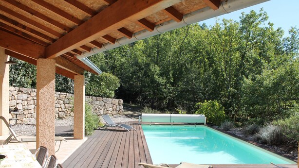 A wooden deck with a pool, lounge chairs, and a table with chairs. - House / Villa - St genest de beauzon (Saint Genest de Beauzon)