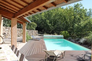 A wooden deck with a pool, lounge chairs, and a table with chairs. - House / Villa - St genest de beauzon (Saint Genest de Beauzon)