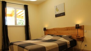 A bedroom with a bed, a nightstand, a lamp, a window with curtains, and a wall-mounted artwork. - House / Villa - St genest de beauzon (Saint Genest de Beauzon)