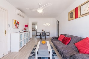 Un salon moderne comprenant un canapé, une table basse et un coin repas avec des chaises et une table.