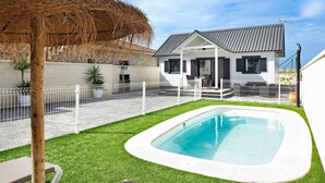 A house with a swimming pool, a covered patio, and a fenced backyard. - Chalet "Casa Manoli" with Pool, Terrace, Air Conditioning and Wi-Fi (Barrio Nuevo)