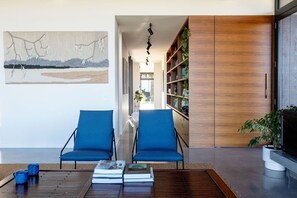 Relax in this stylish living room, featuring a comfortable seating area, a functional workspace, and a beautiful abstract art piece.