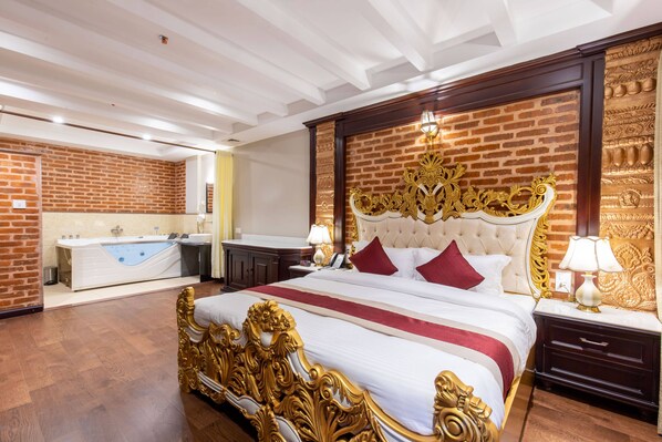 Un dormitorio lujoso con una cama grande, un baño independiente con bañera y un diseño de pared de ladrillo.