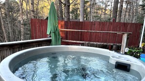 A hot tub with a wooden deck and a wooden fence in the background. - About Time ~~ About You  (Asheville)