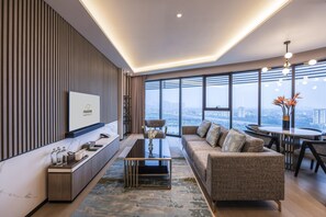 Habitación Deluxe, 2 habitaciones | Zona de estar | Televisión LED de 49 pulgadas con canales por cable, una televisión