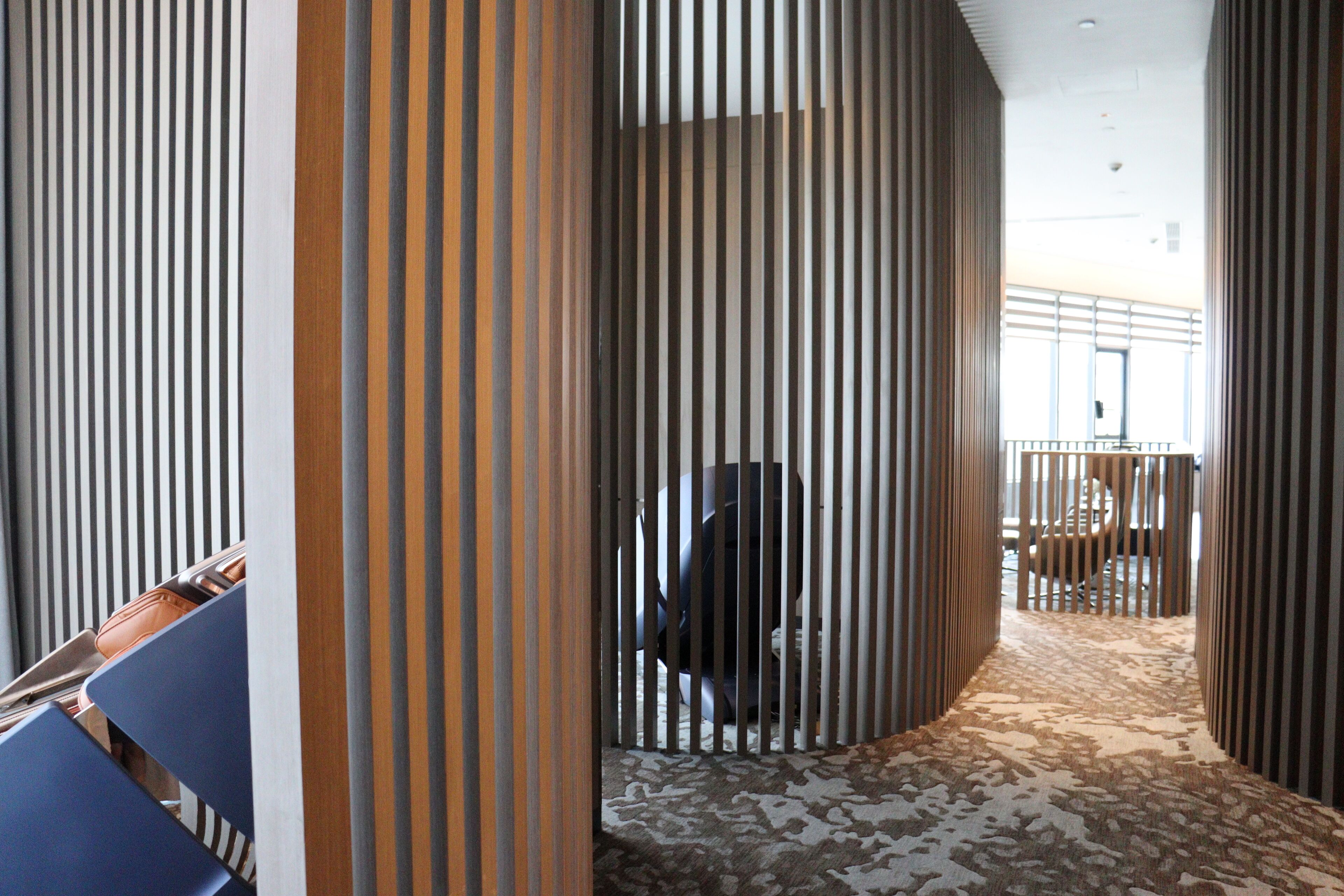 A corridor with vertical striped panels and a patterned carpet.