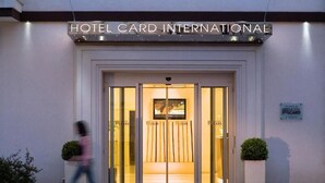 La entrada del Hotel Card International con una puerta de vidrio y un cartel arriba.