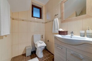 A modern bathroom with a toilet, sink, and mirror. - Villa Orestis - Faraggi Villas (Zoniana)
