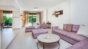 A modern living room with a sofa set, a coffee table, and a dining area with a table and chairs.