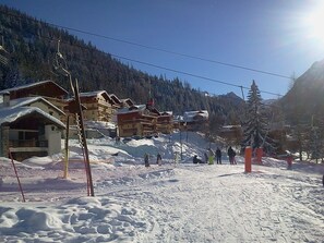 A ski resort with multiple buildings, including a lodge with a sloped roof and a ski lift visible. - 3BR+Cabin Apt, 8 ppl, near ski lifts, parking (Valfréjus)
