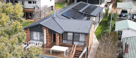 Un edificio residencial con techo plano, una zona de estar al aire libre cubierta y una escalera visible que conduce al nivel superior.