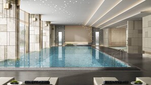 A modern indoor swimming pool with clear water, surrounded by stone walls and a ceiling with recessed lighting. - Courtyard by Marriott Liuzhou Sanjiang (Liuzhou)