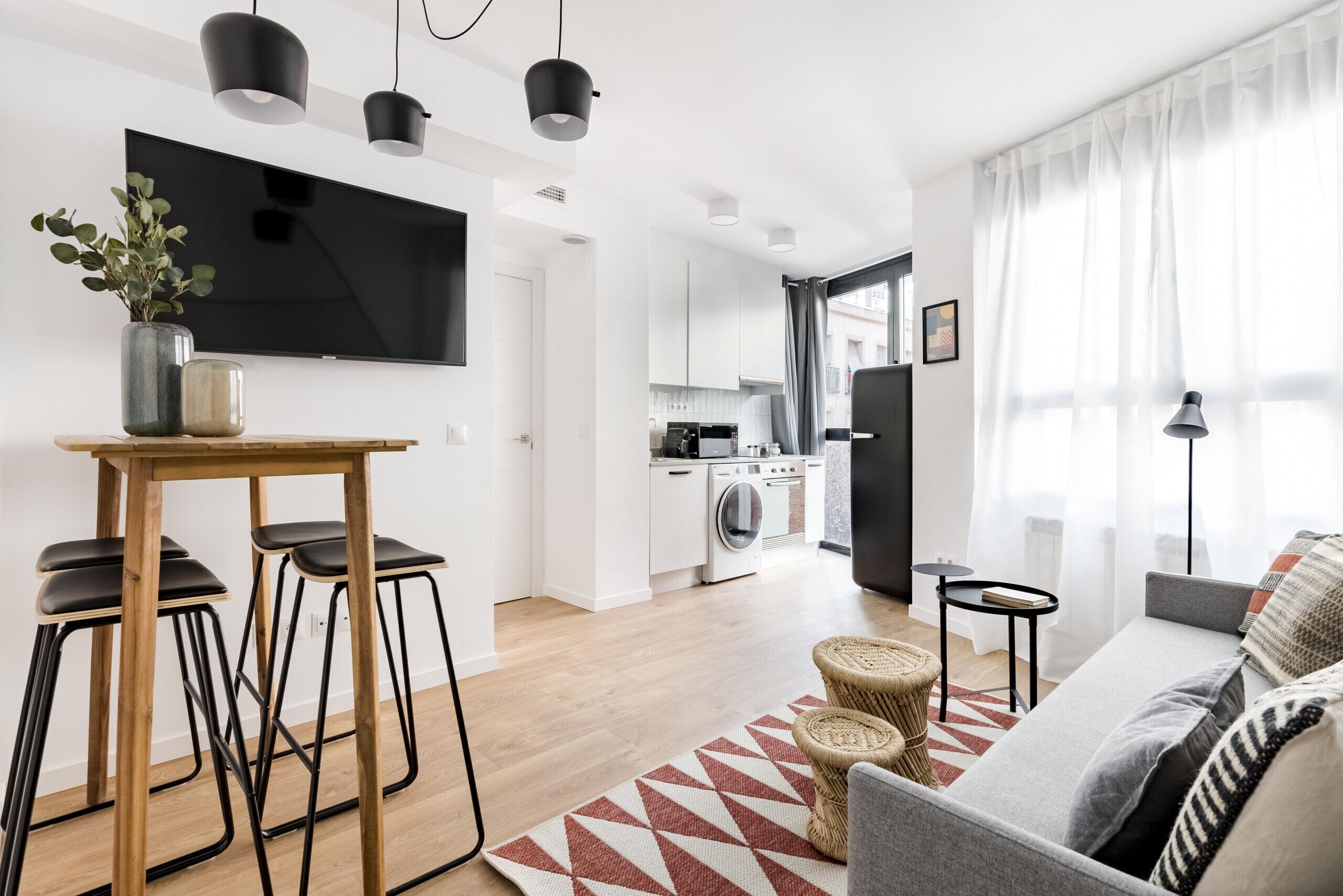 A modern apartment with a dining area, kitchen, and living space.