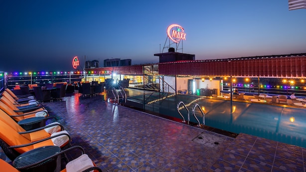 A rooftop pool area with lounge chairs and a bar. - Hotel Maxx (Kohalpur)