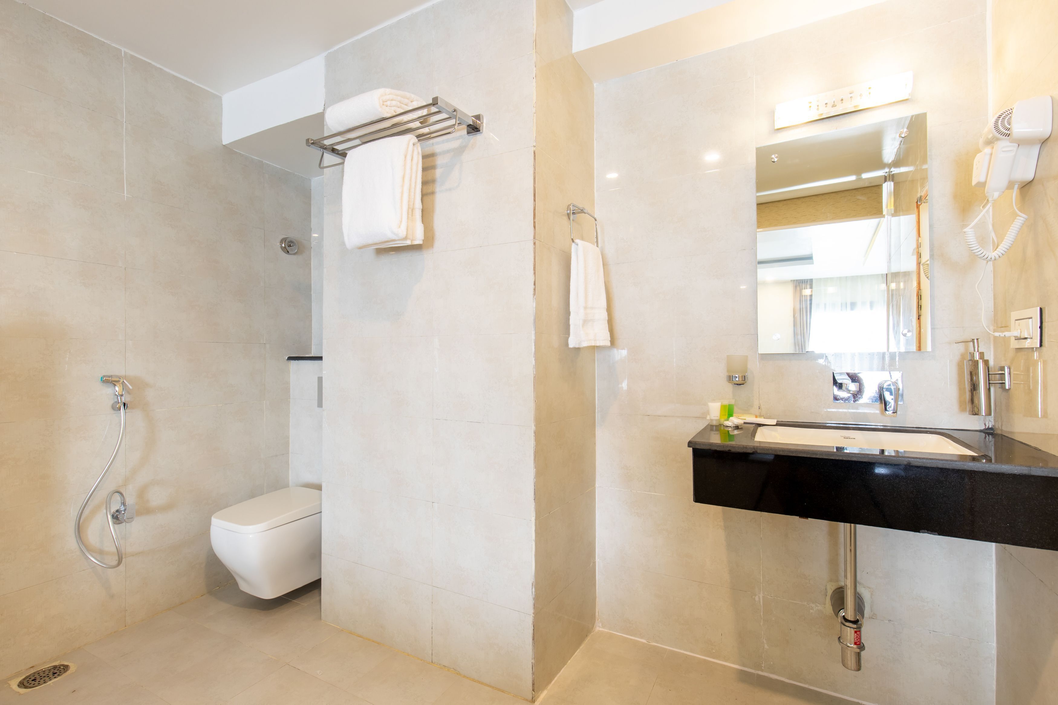 A modern bathroom with a toilet, shower, and sink.