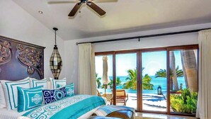 A bedroom with a bed, a ceiling fan, a view of the beach, and a sliding glass door. - Beachfront Palmilla Villa with Private Beach Walk (San José del Cabo)