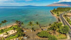 A coastal view with a beach, palm trees, and a road curving along the shore. - Two homes w/ pool and hot tub near 3 beaches, Kihei (Kihei)