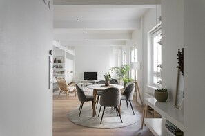 Ett modernt matområde med ett runt bord, fyra stolar och en centralt placerad växt.