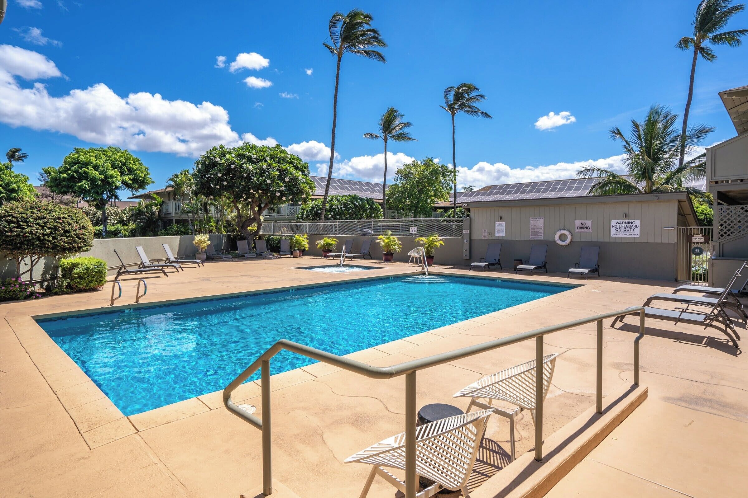 A swimming pool with lounge chairs and a lifeguard station.