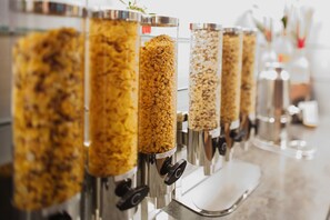 A row of food dispensers with various grains and flakes. -  Intercityhotel Amsterdam Schiphol Airport (Hoofddorp)